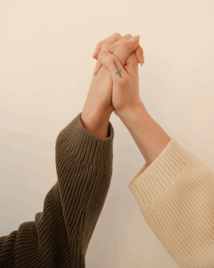 Hands held together, representing care and women’s wellness support