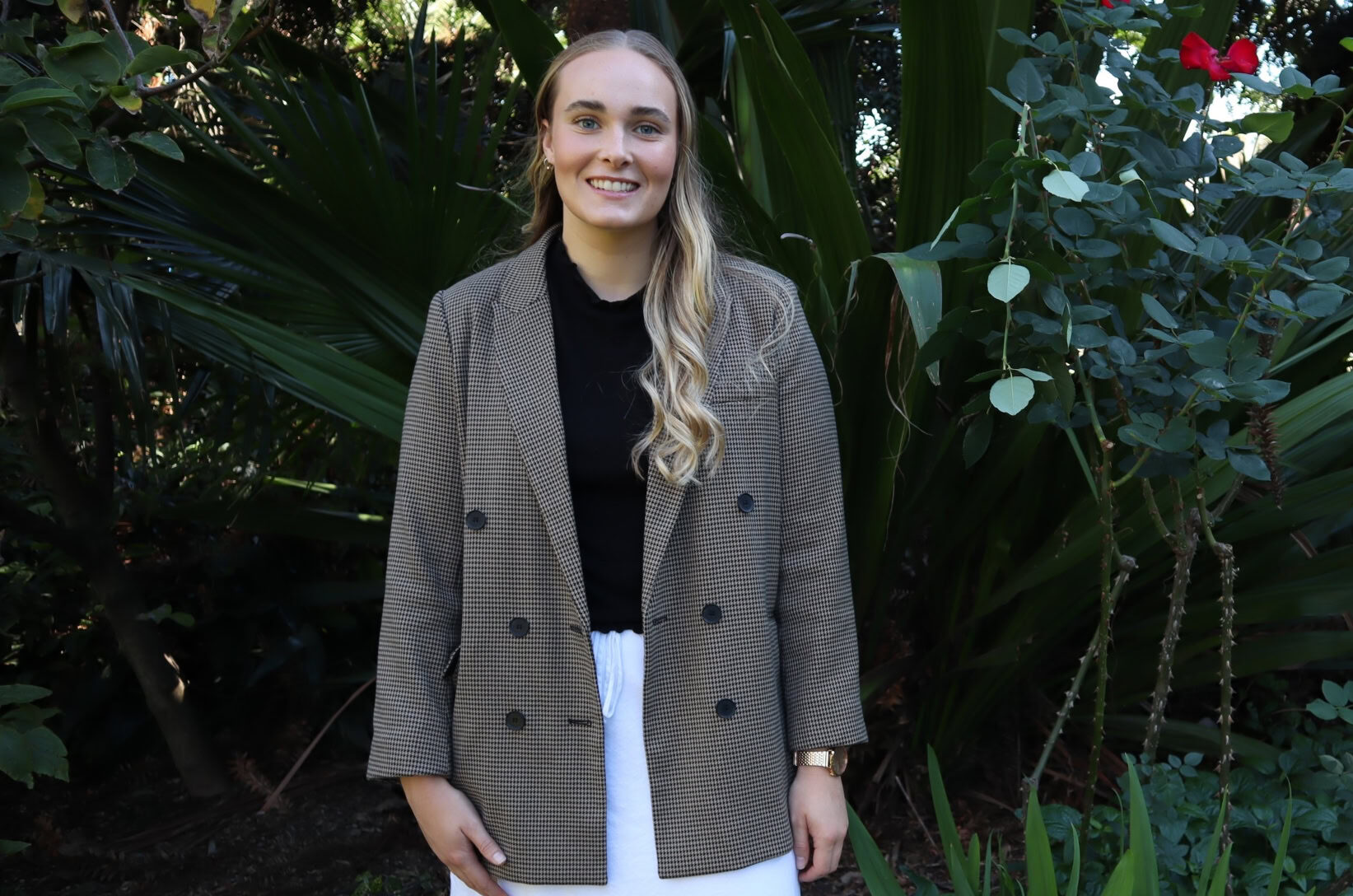 Caitlin Britten, women’s gut and hormone naturopath, standing in greenery